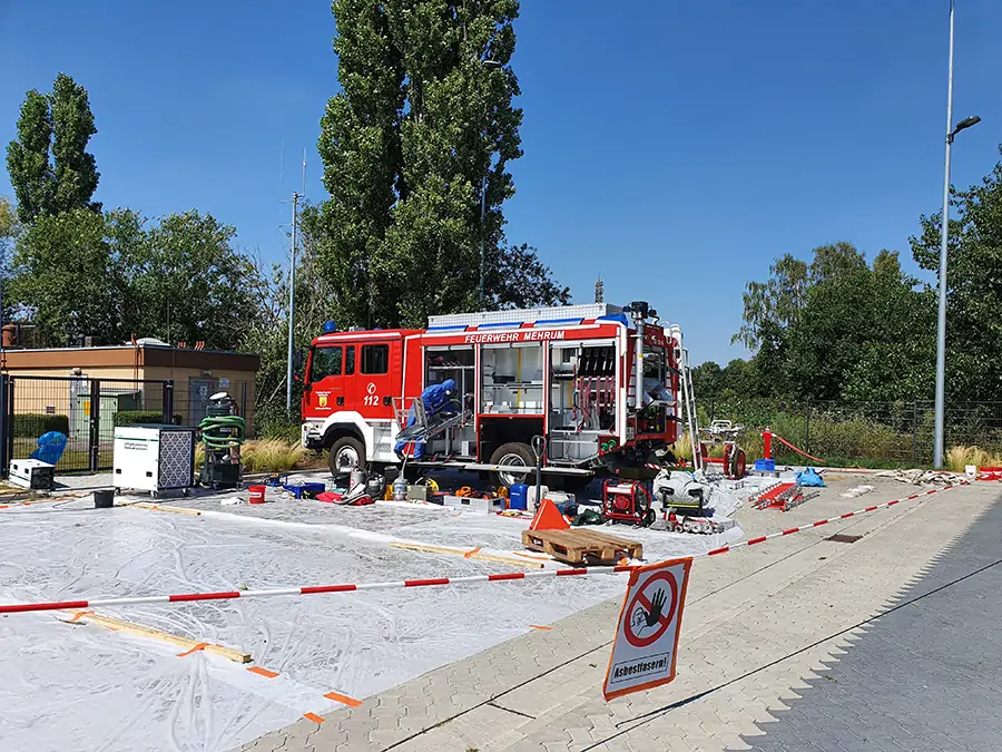 Reinigung der eingesetzten Schutzkleidung und Gerätschaften nach der Brandbekämpfung mit Asbestaustritt
